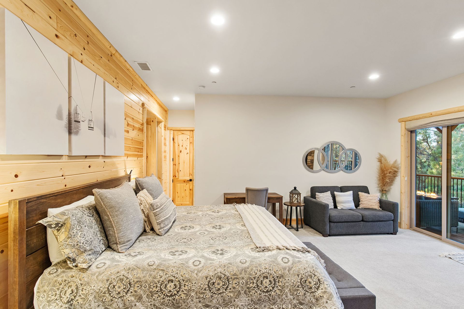 A bedroom with a large bed , couch , and sliding glass doors.