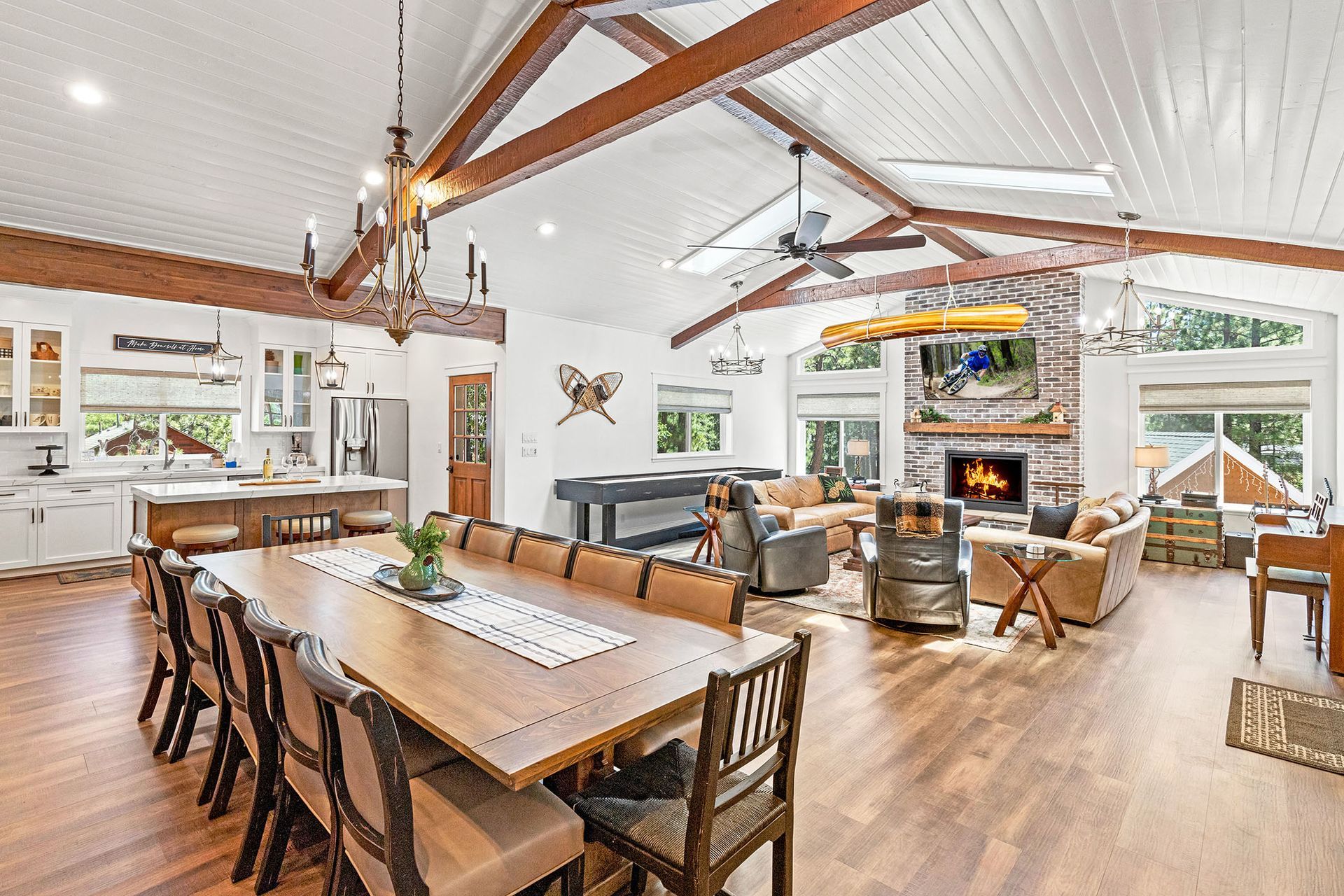 A large living room with a dining table and chairs and a fireplace.