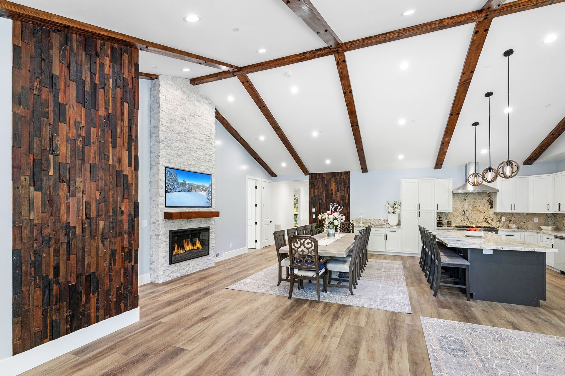 A living room , dining room , kitchen and fireplace in a house.