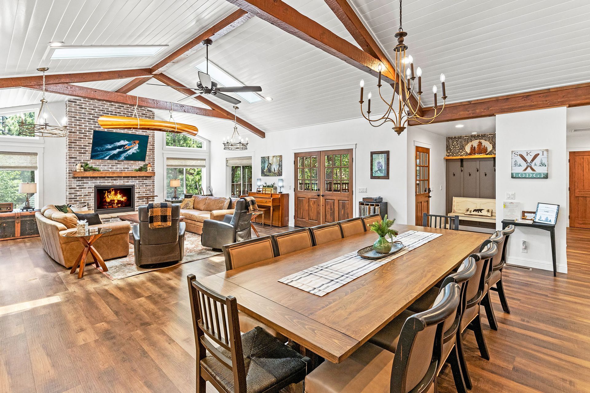 A large living room with a dining table and chairs and a fireplace.
