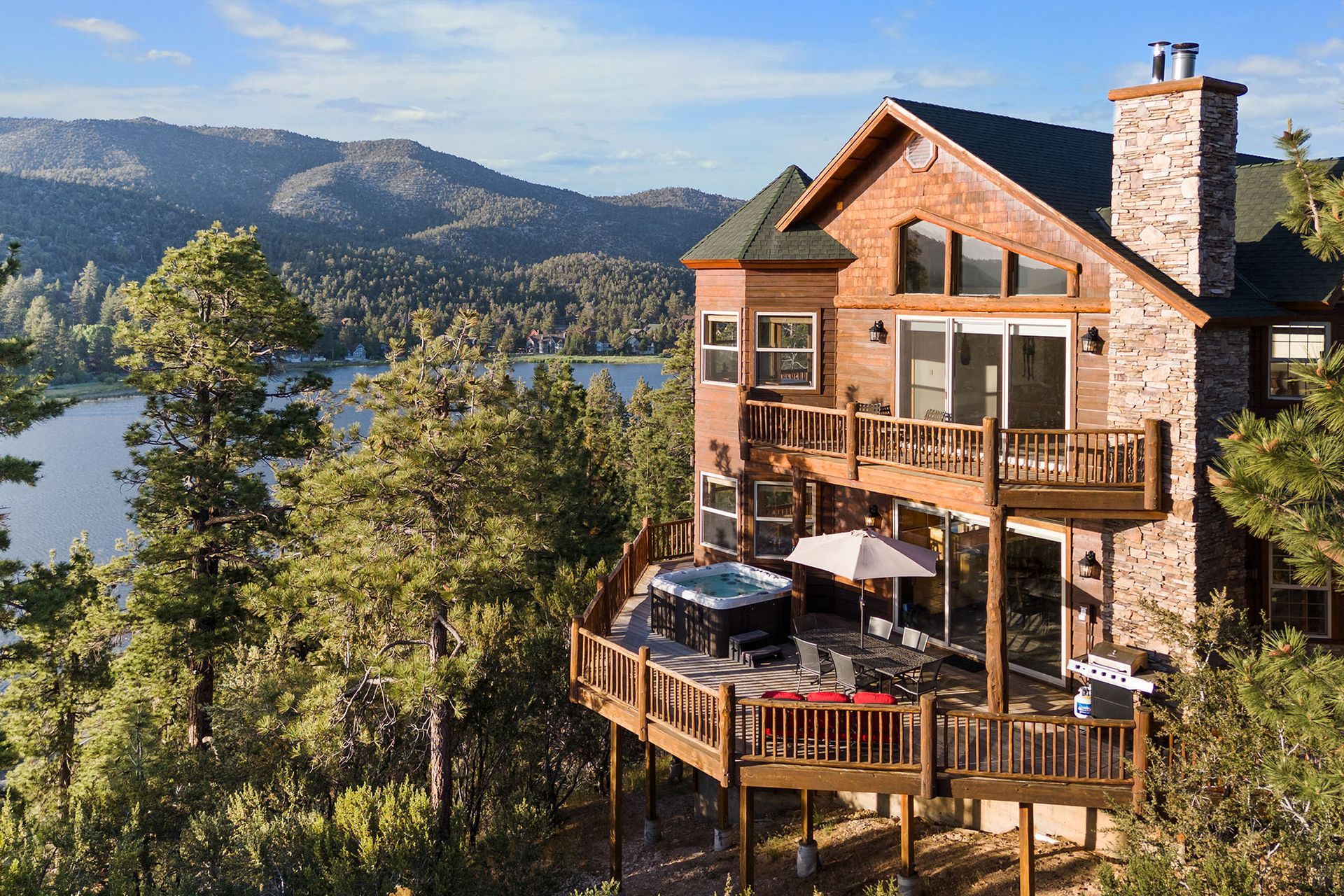 A large house with a large deck overlooking a lake