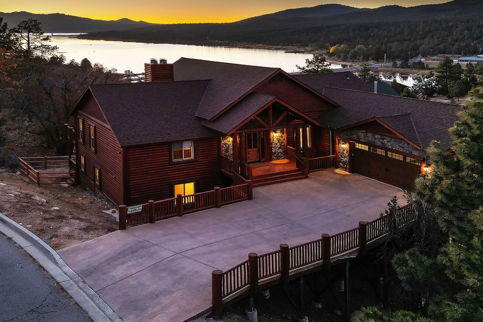 An aerial view of a large house with a lake in the background
