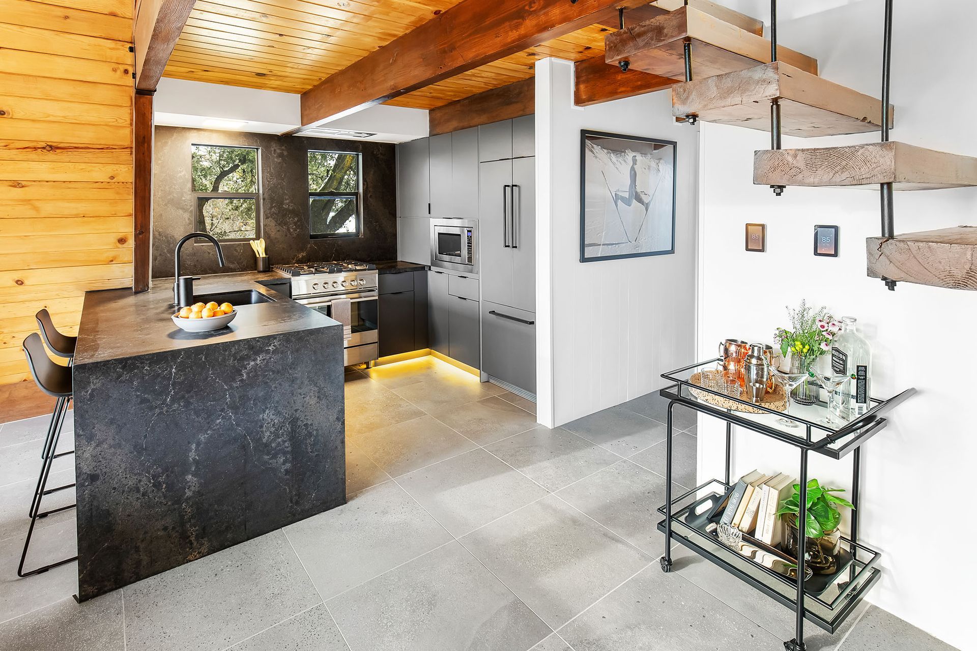 A kitchen with a large island and a wooden staircase.