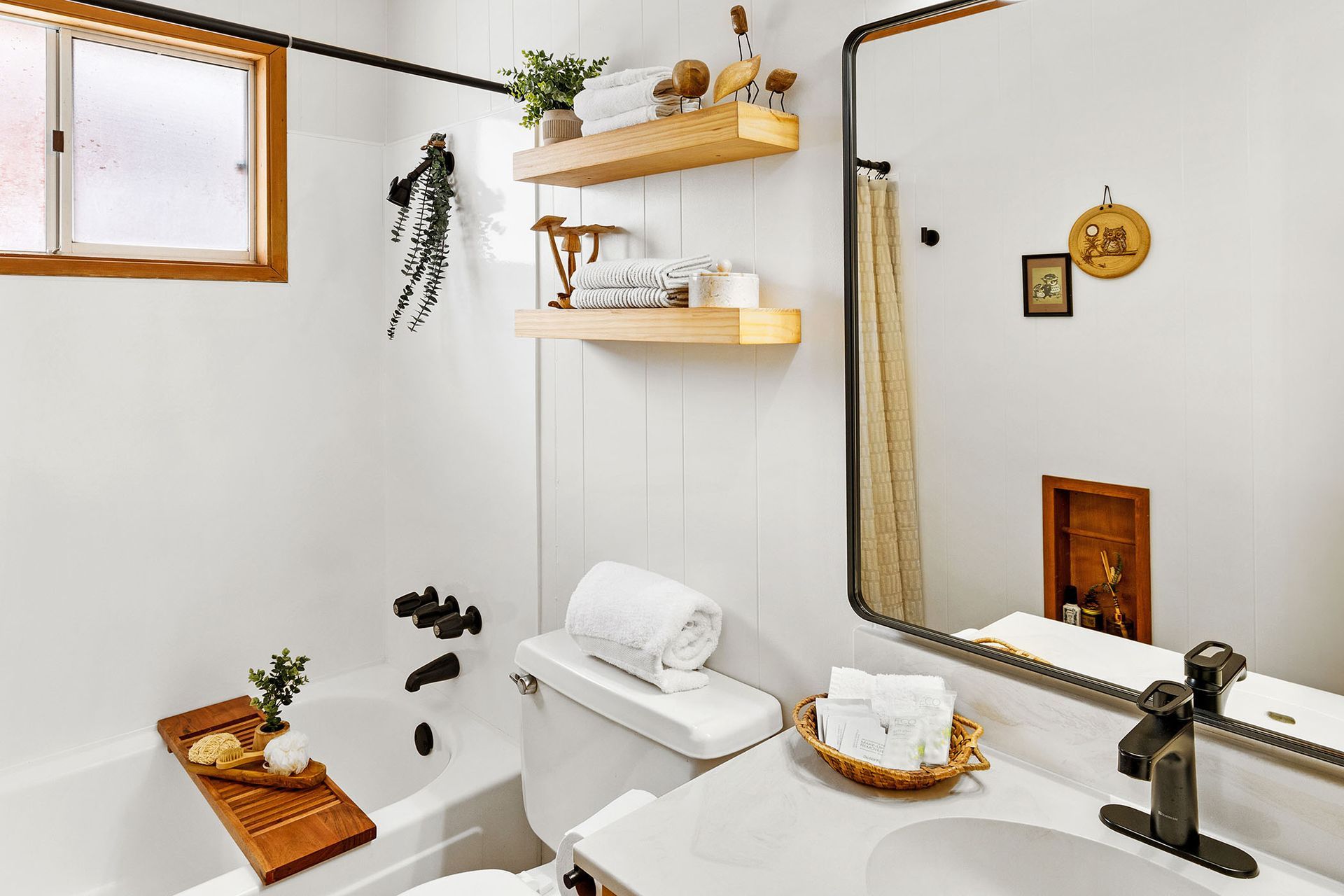 A bathroom with a sink , toilet , bathtub and mirror.