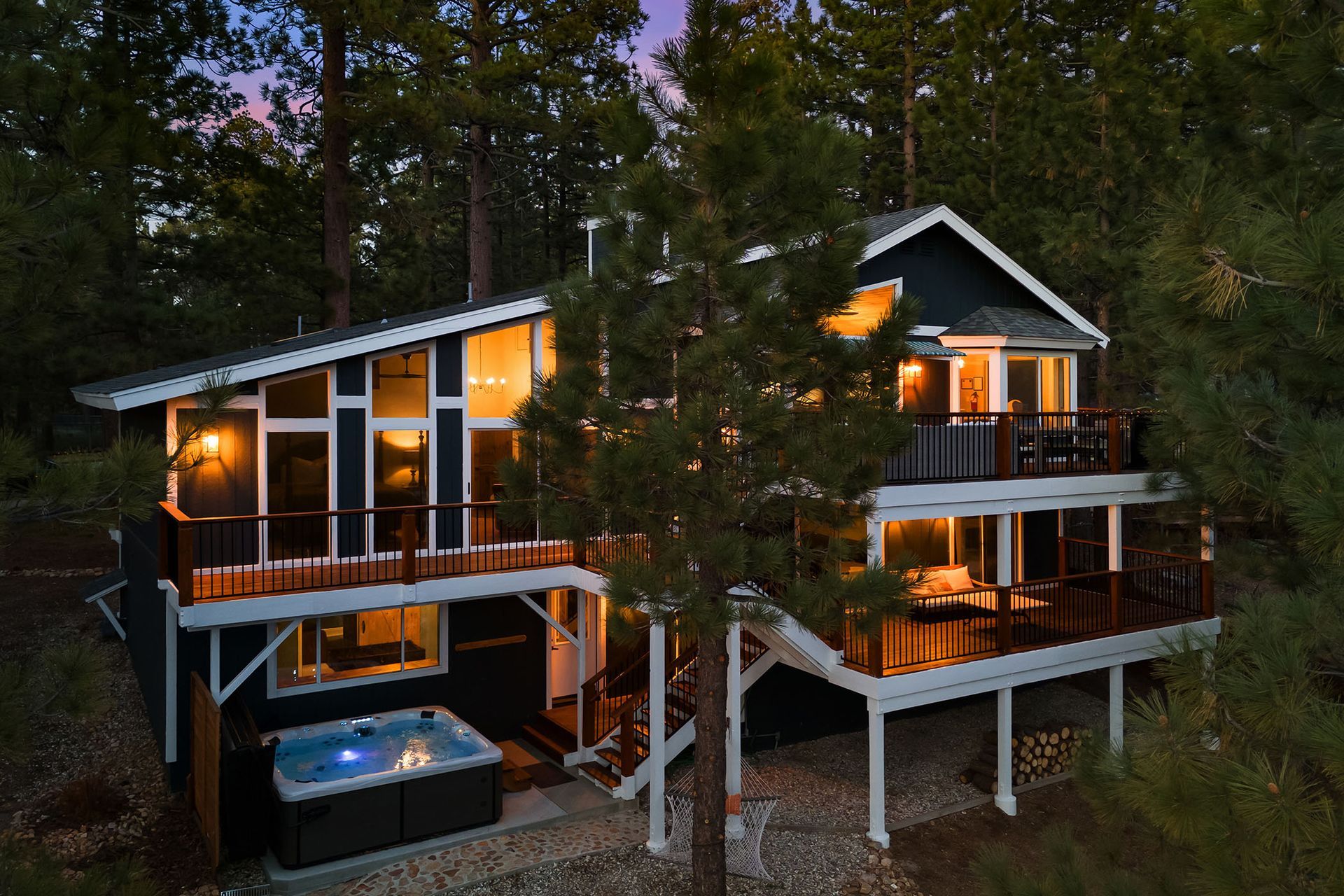 An aerial view of a house with a hot tub in the middle of the woods.