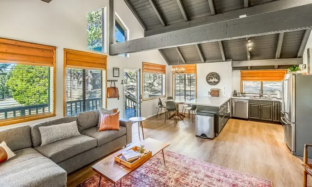 A living room with a couch , coffee table , and kitchen.
