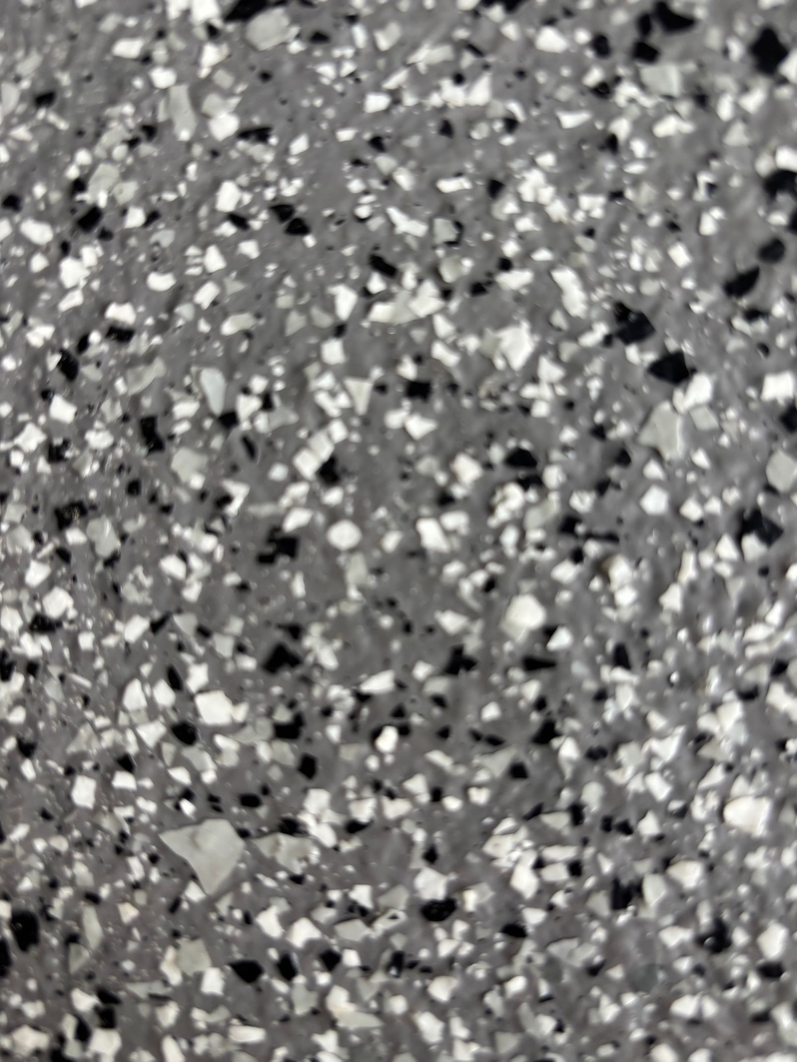 Sol gris moucheté de noir, de blanc et de gris clair.
