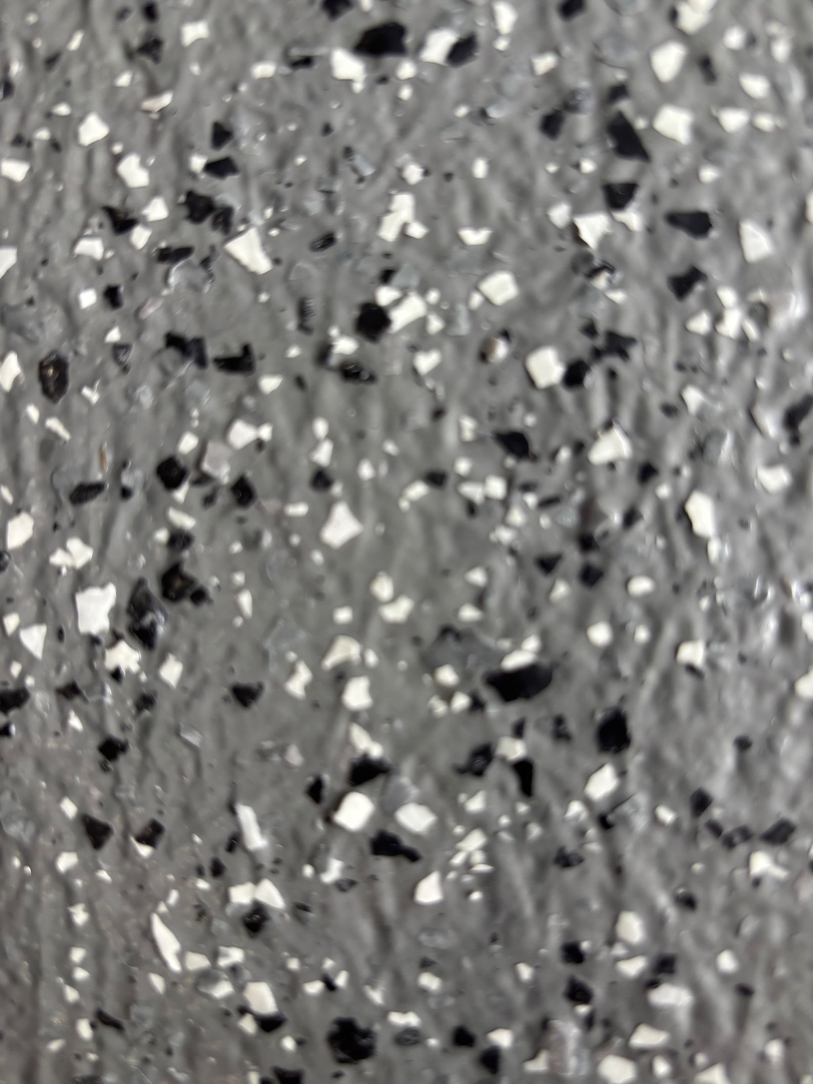 Sol gris moucheté de noir et de blanc.