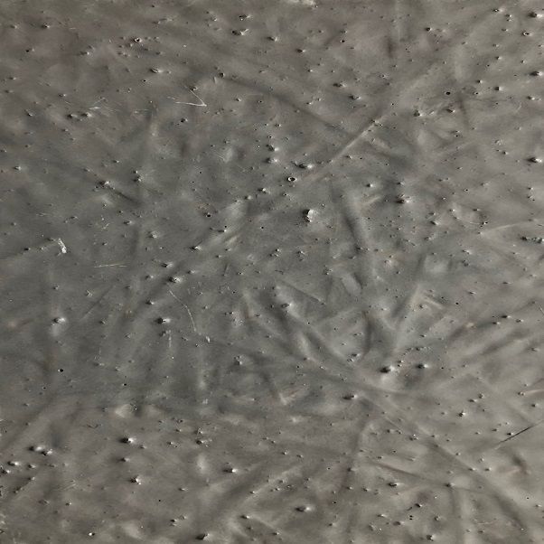 Surface grise et texturée, présentant des rides et de petites bosses.