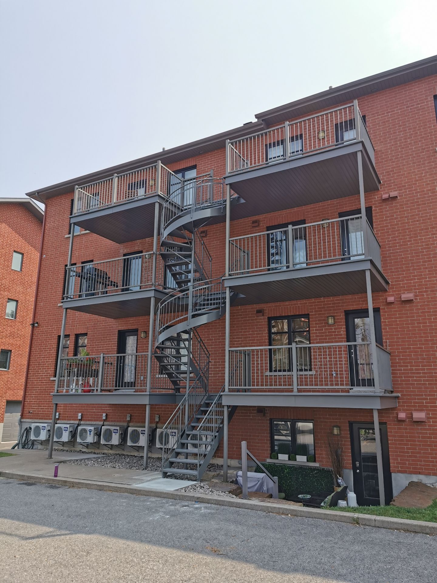 Extérieur d'un bâtiment en briques avec un escalier de secours en métal.