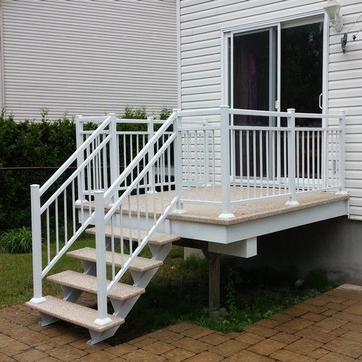 Terrasse et escalier blancs avec rambarde menant à une porte-fenêtre coulissante. Terrasse et marches d'escalier en composite.