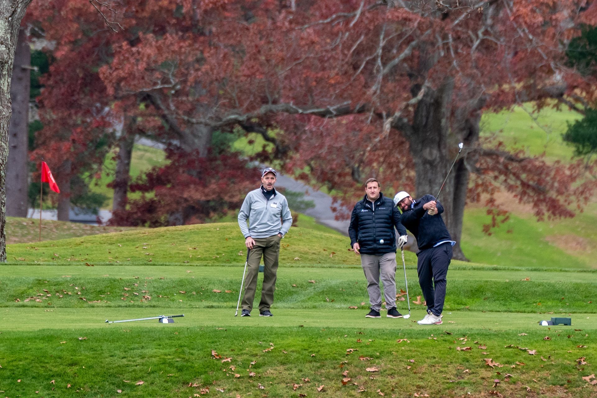 Three men playing golf.
