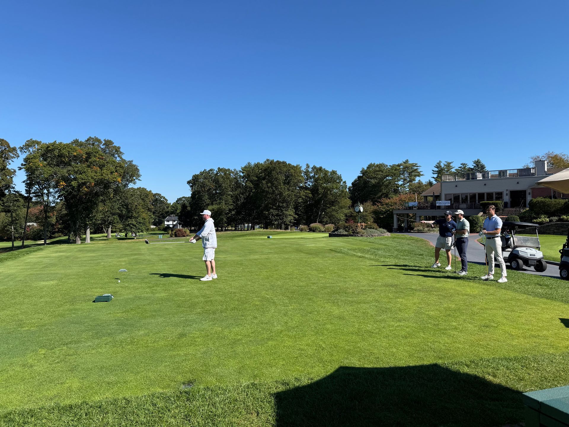 Four men are posing for a picture on a golf course