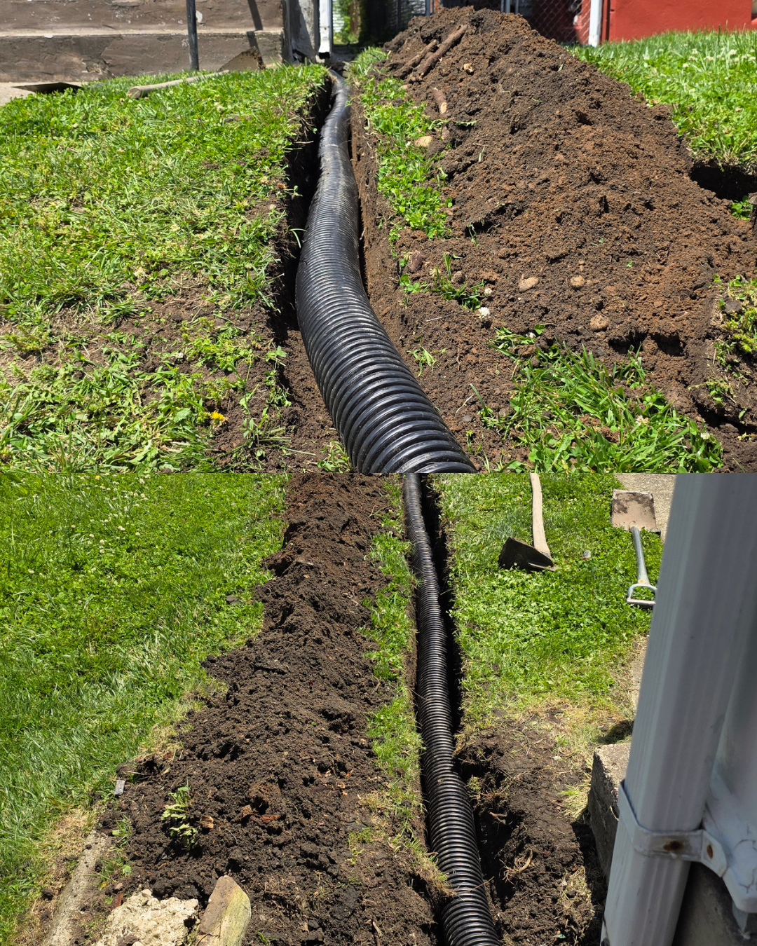 Black corrugated drain pipe in a dug trench beside a lawn and house foundation