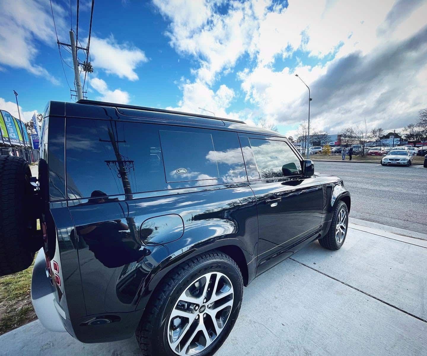 Black Suv Parked on A Street Under a Cloudy Blue Sky — Diamond Window Tints in Phillip, ACT