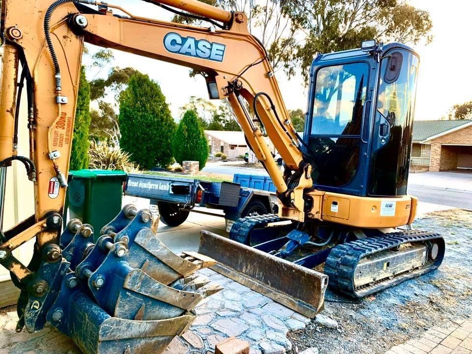 A Case Excavator is Parked on the Side of the Road — Diamond Tints In Phillip, ACT