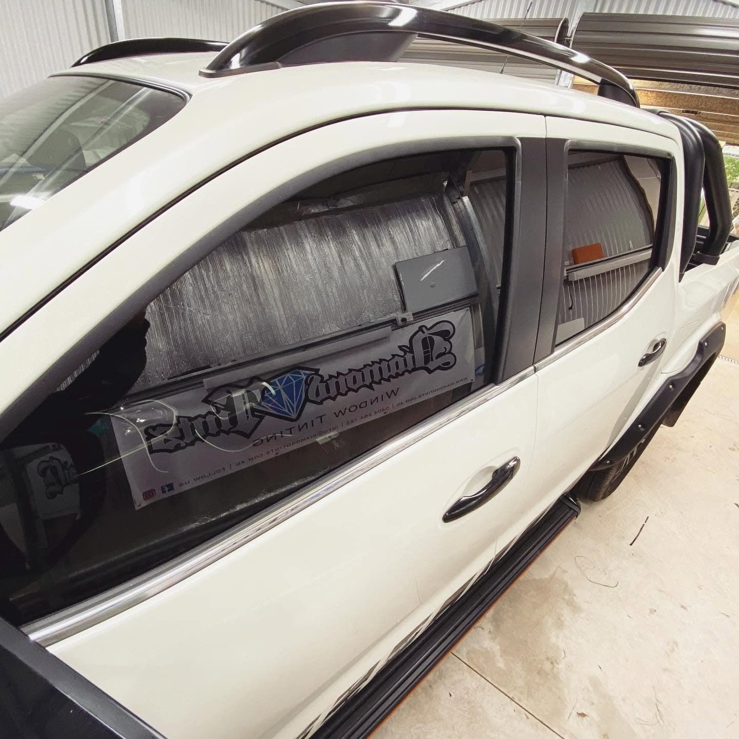 White Suv with Tinted Windows and Roof Cargo Box Parked Indoors — Diamond Window Tints in Phillip, ACT