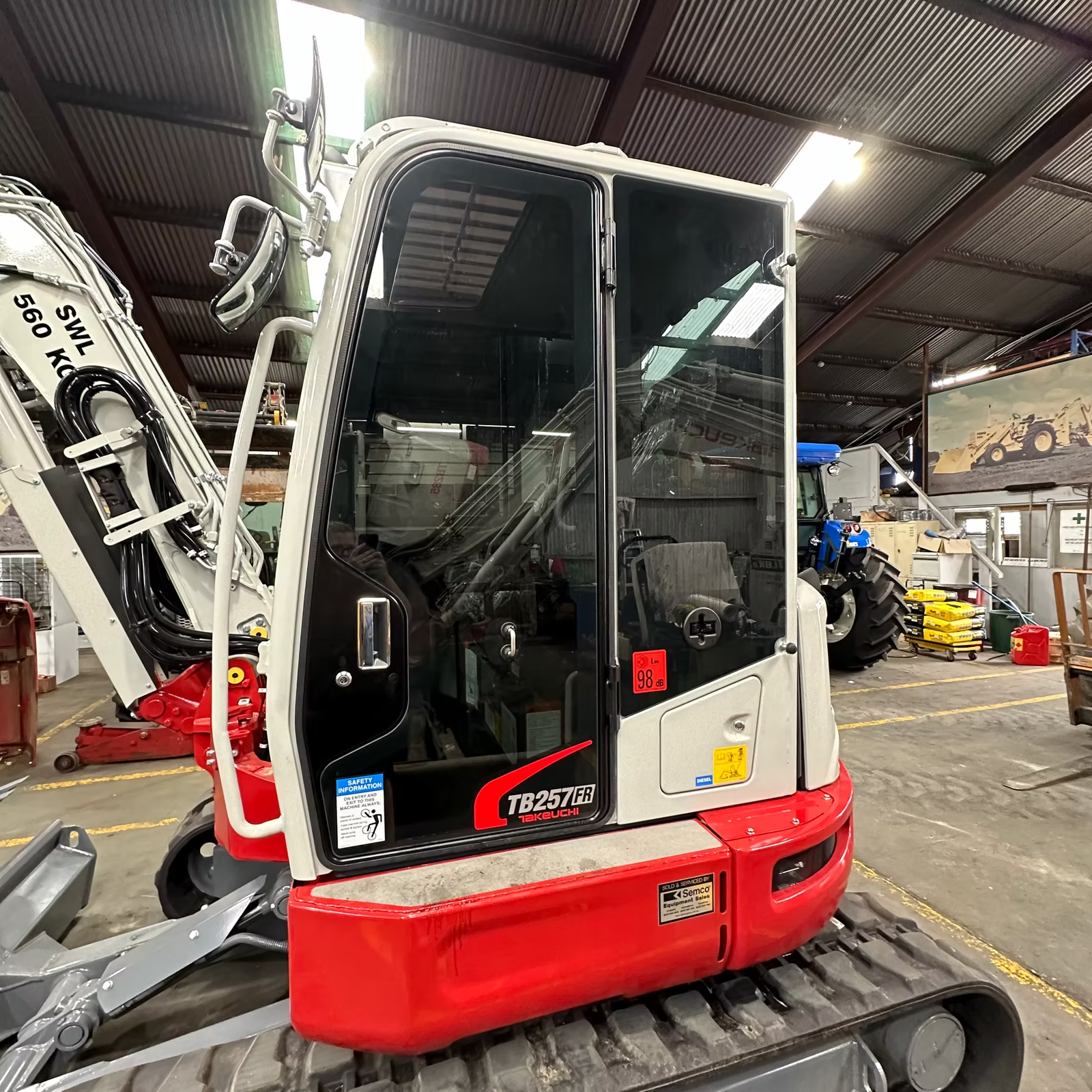 A Red and White Excavator is Parked in a Warehouse — Diamond Tints In Phillip, ACT