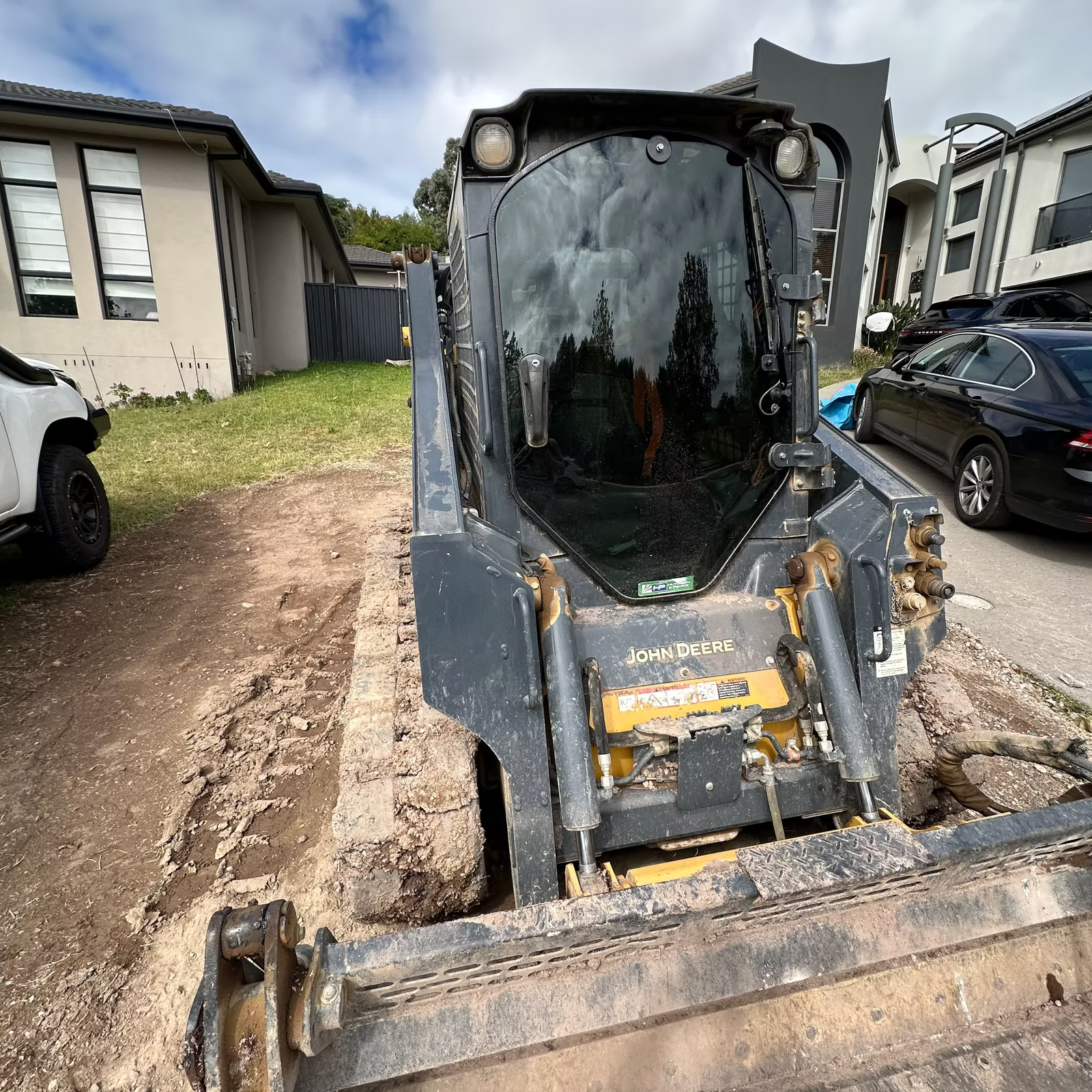 A Bulldozer is Sitting in the Dirt in Front of a House — Diamond Tints In Phillip, ACT