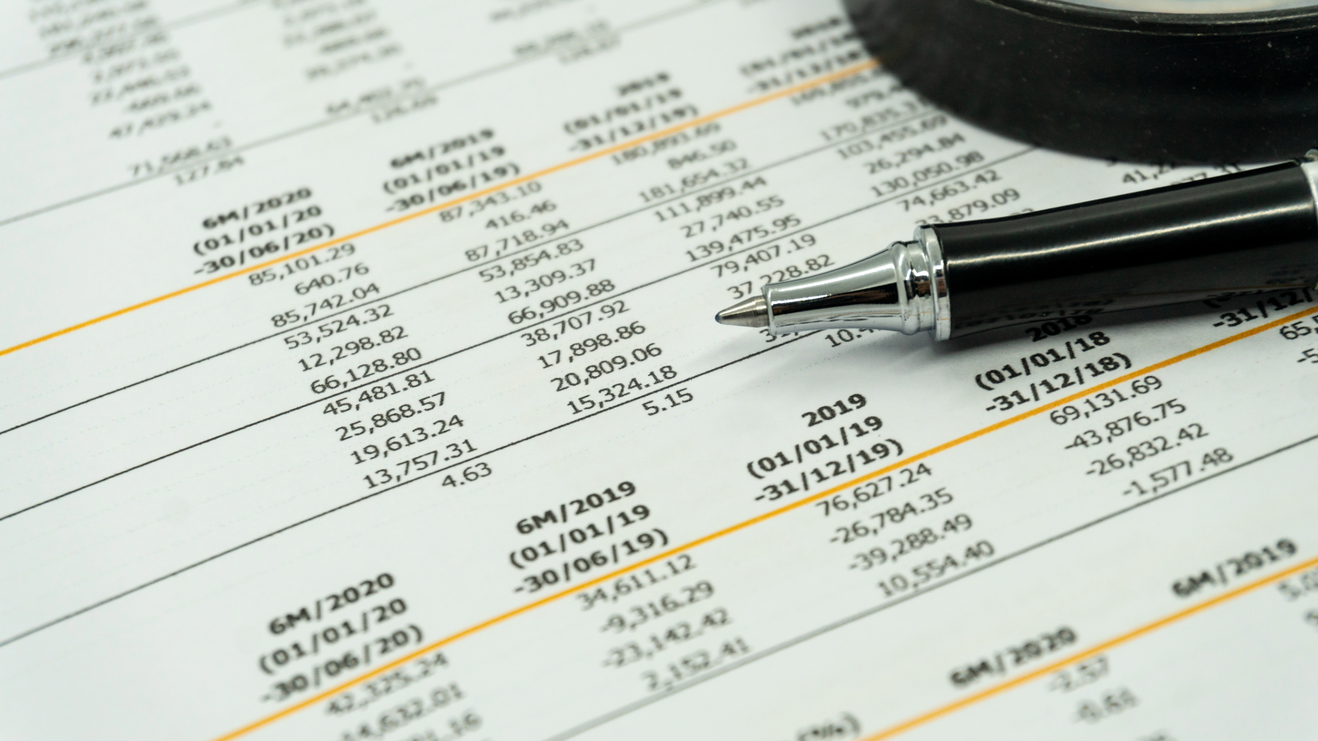 Financial statements close up photo with a pen.