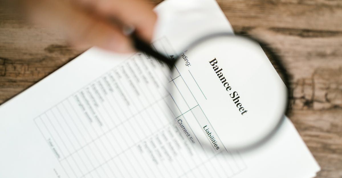 Magnifying glass over a balance sheet.