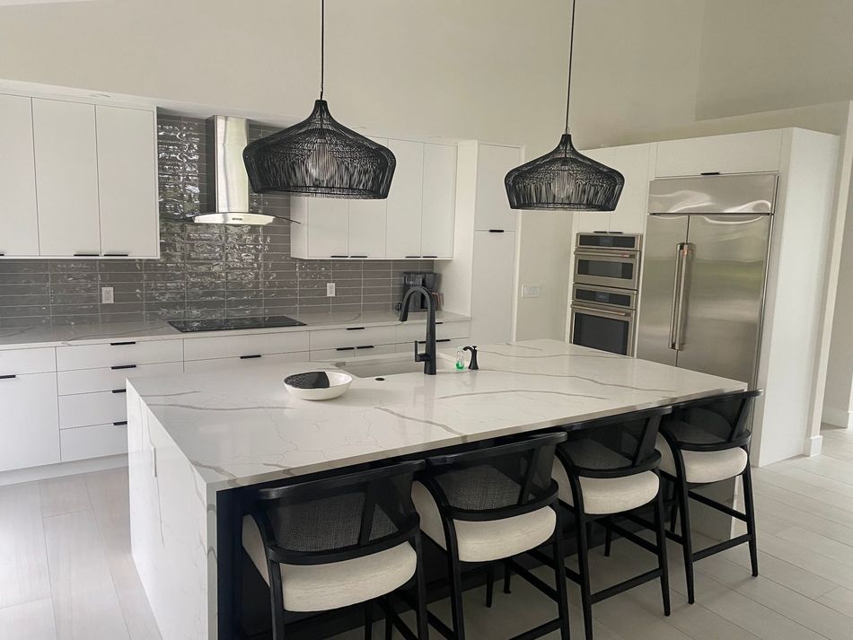 A kitchen with white cabinets and a large island