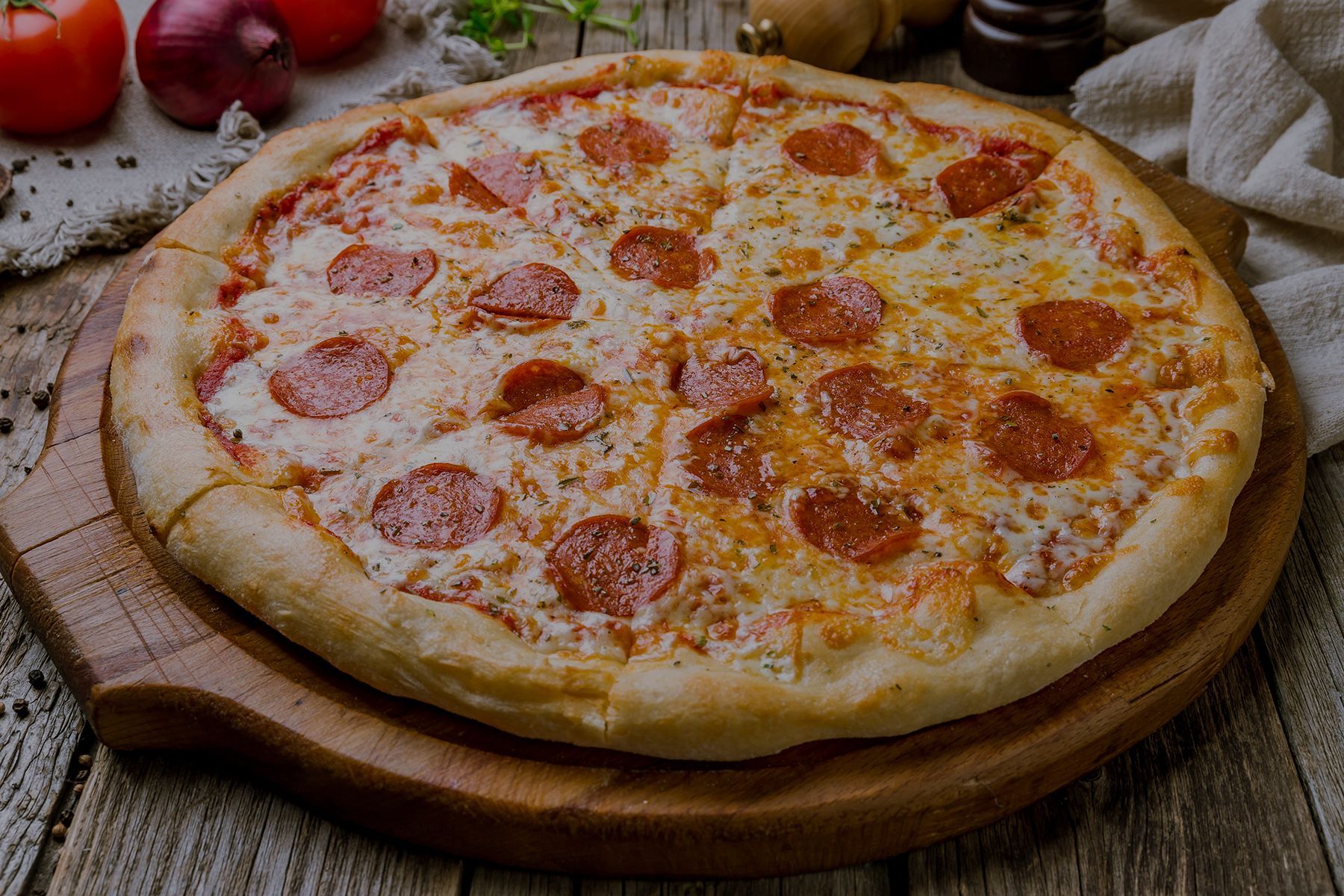 Pizza with pepperoni and cheese on a wooden board.