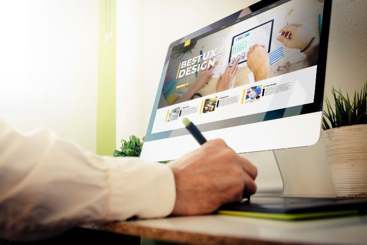 a person is using a pen to draw on a computer screen .