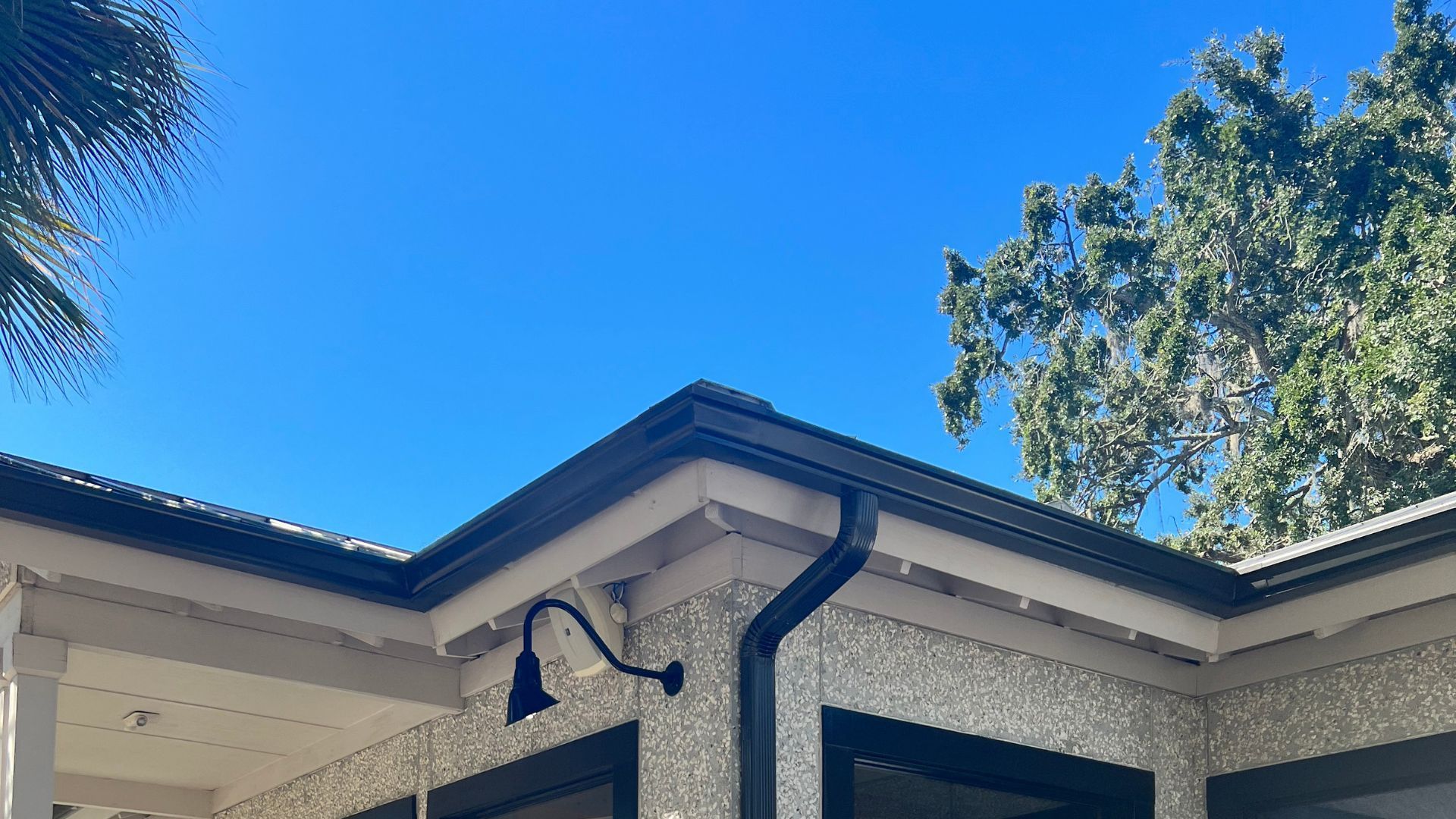 A house with a gutter and a light on the side of it.