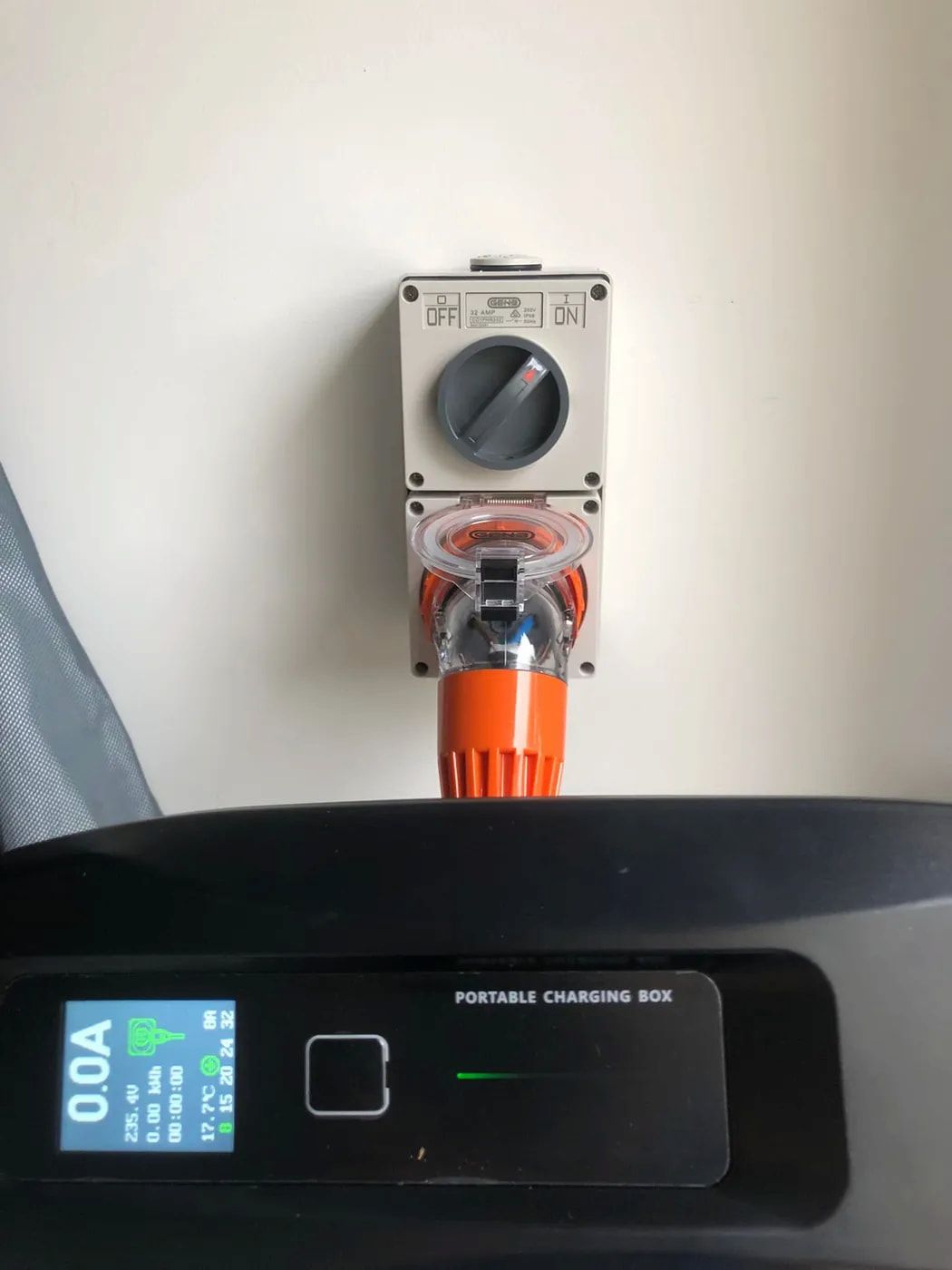 Black charger dock with orange plug below a wall-mounted switch panel and display. — Technik Electrical in Bundanoon, NSW