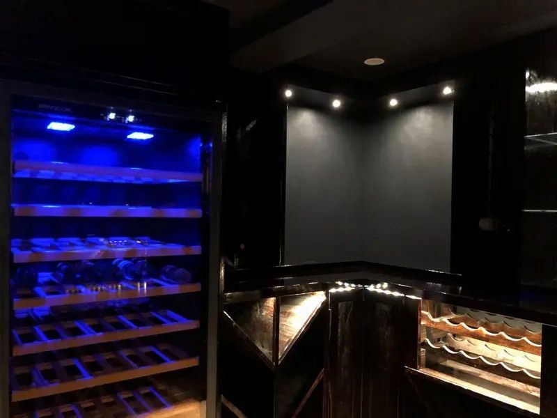 A Modern Home Bar Featuring a Wine Refrigerator With Blue Interior Lighting — Technik Electrical in Renwick, NSW