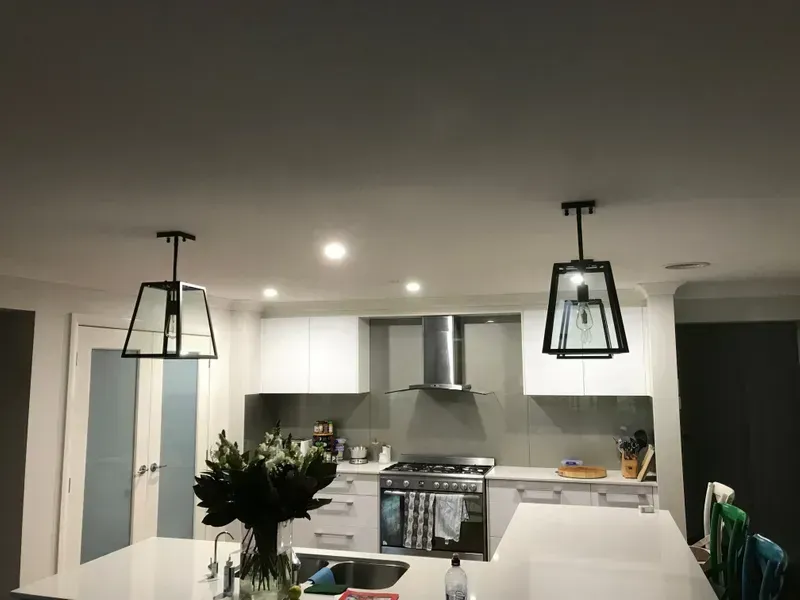 Modern Kitchen With White Cabinets, Black Pendant Lights — Technik Electrical in Renwick, NSW