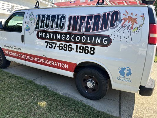 White Arctic Inferno heating and cooling van with contact info, parked on a driveway.