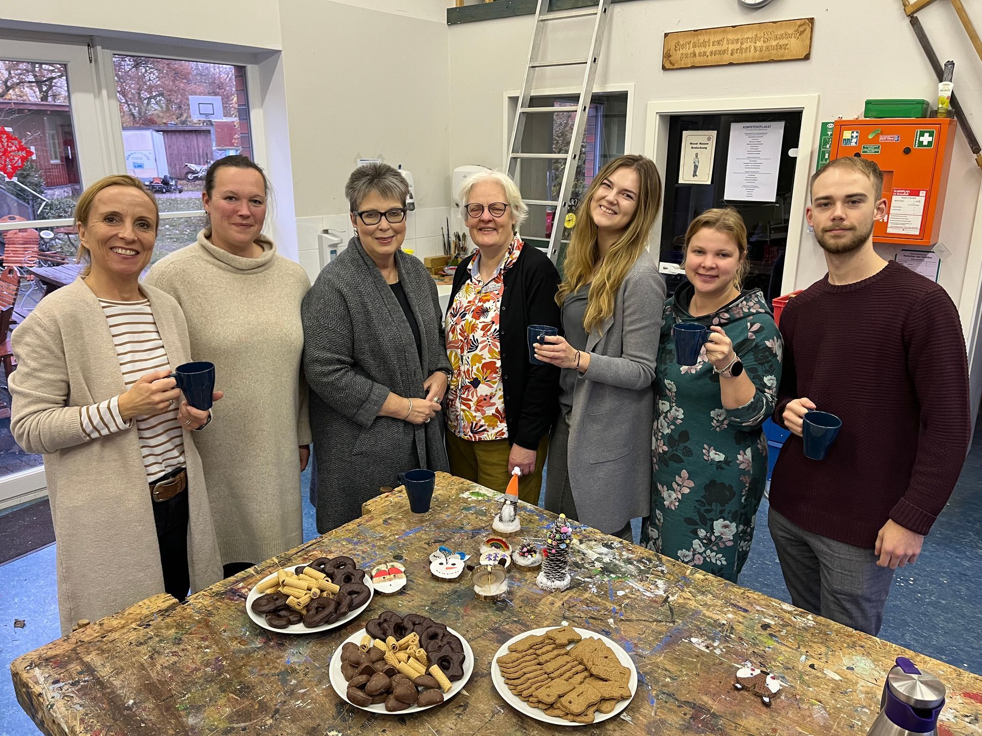Bild von den Organisatorenteam. Das sind 6 verschiedene Frauen und ein junger Mann, die weihnachtlich Zusammenstehen und in die Kamera lächeln.
