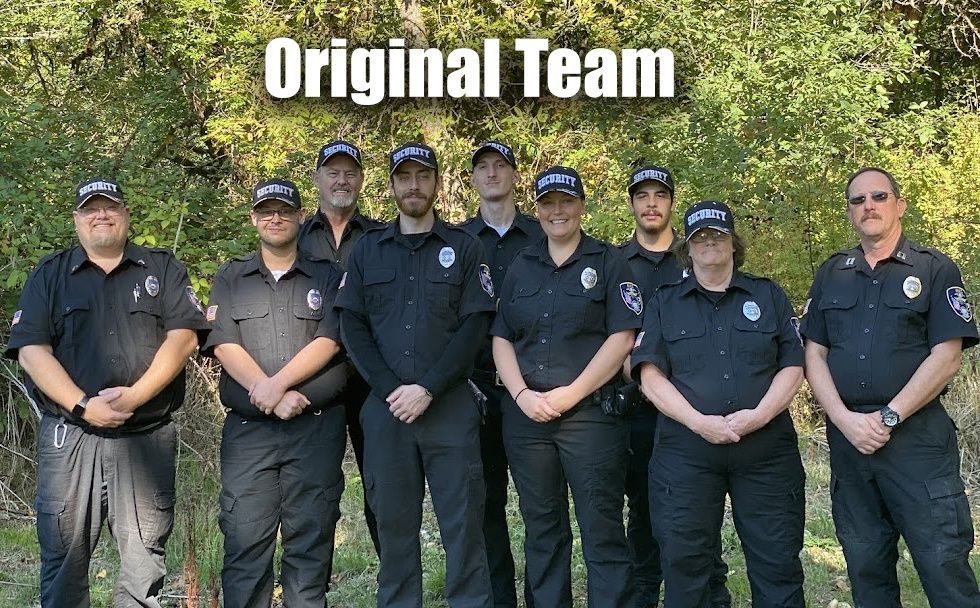 Eight uniformed officers standing outdoors beneath the text “Original Team”
