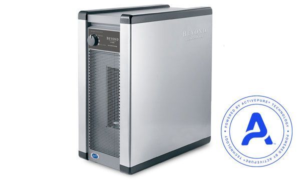 A silver, rectangular air purifier with a front grill and control knob, featuring a circular ActivePure technology logo.