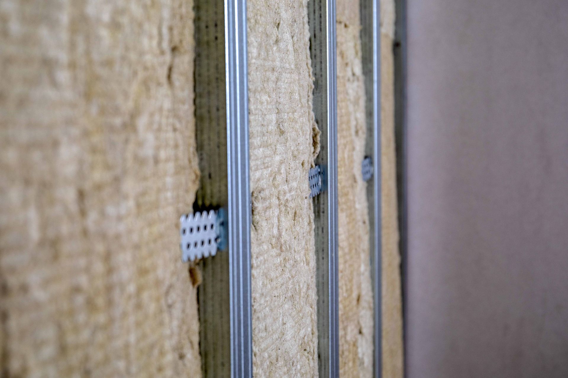 Close-up of insulated wall panels with metal framing and a white fastener between them