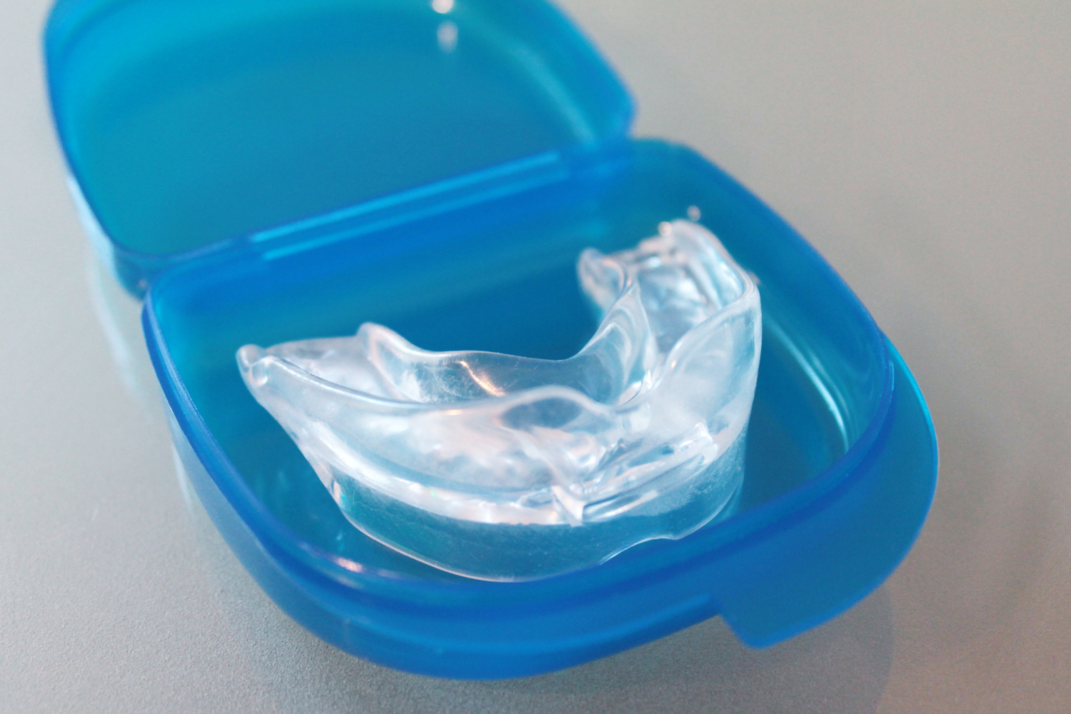Clear dental mouthguard in an open blue case