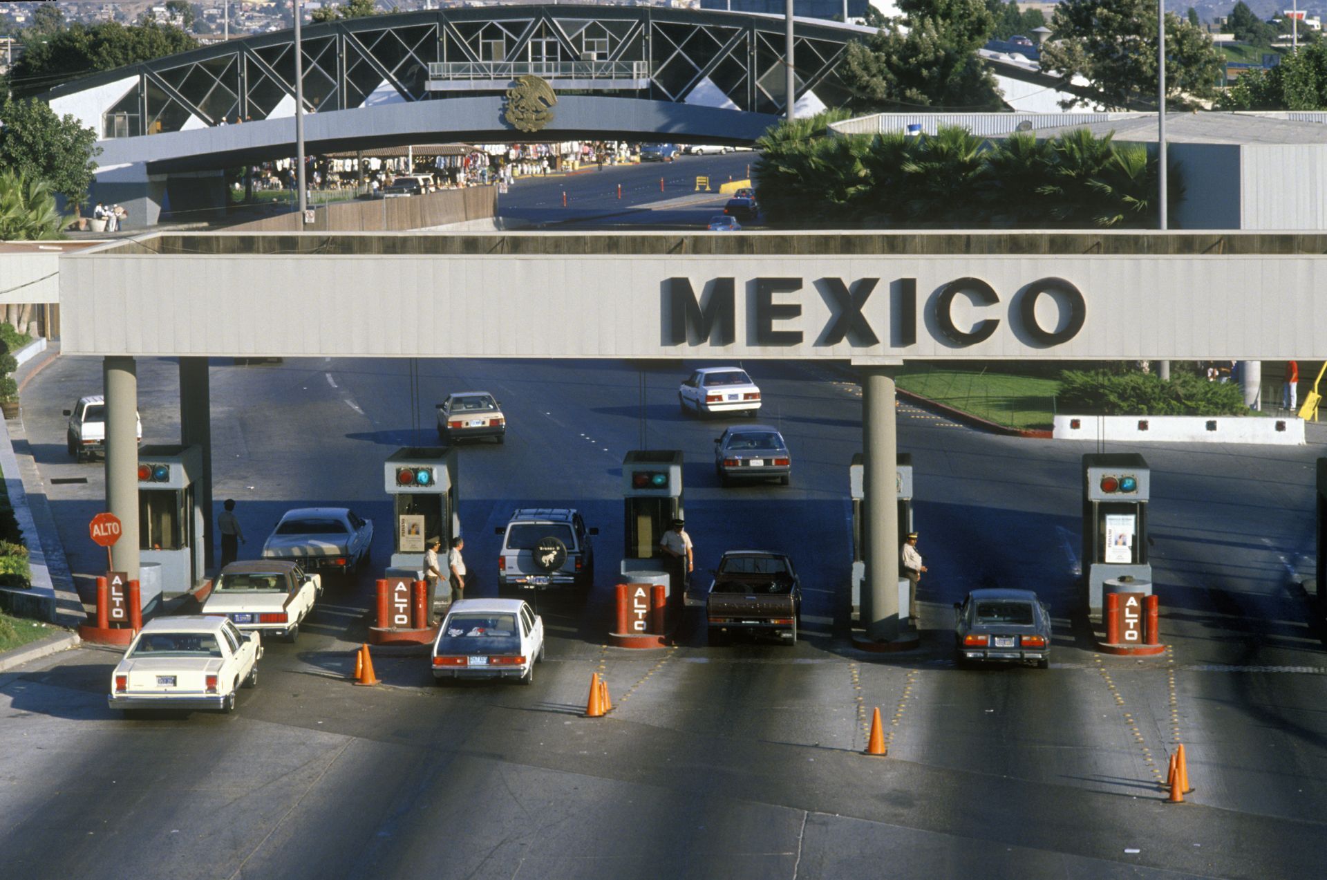 Cars entering Mexico border crossing under a sign that says 