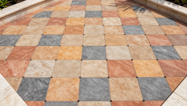 Colorful tiled walkway with orange, gray, and beige square stones in a geometric pattern