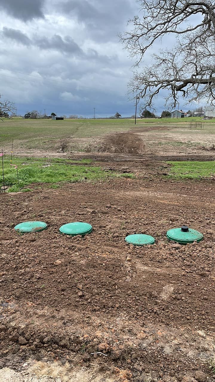 Open field under cloudy sky with four turquoise stepping stones in the foreground.