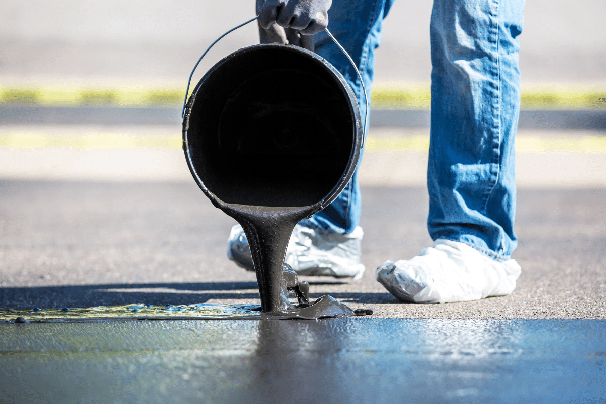worker leveling fresh asphalt on a road construction