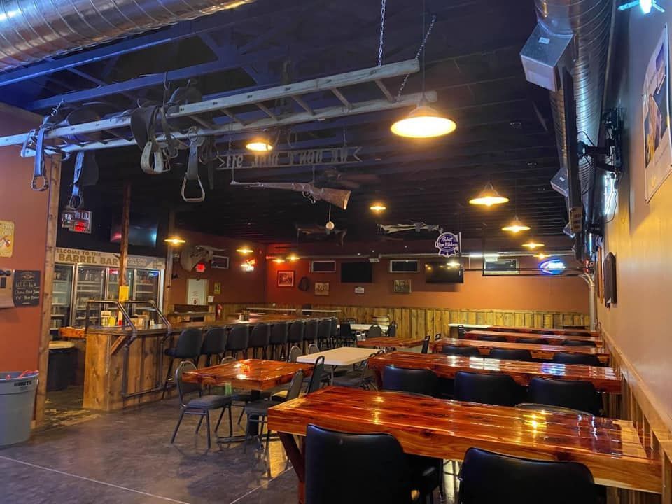 A restaurant with tables and chairs and a bar.