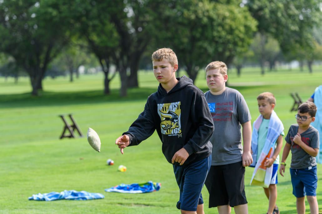 A group of young boys are playing frisbee in a park.
