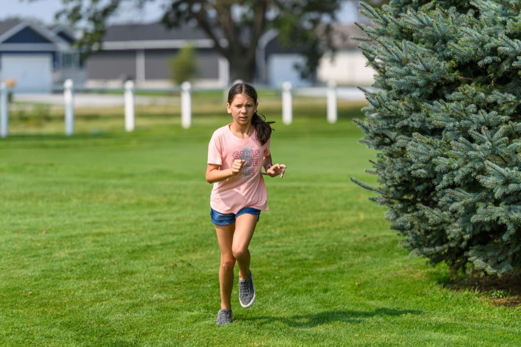 A young girl is running in a park.