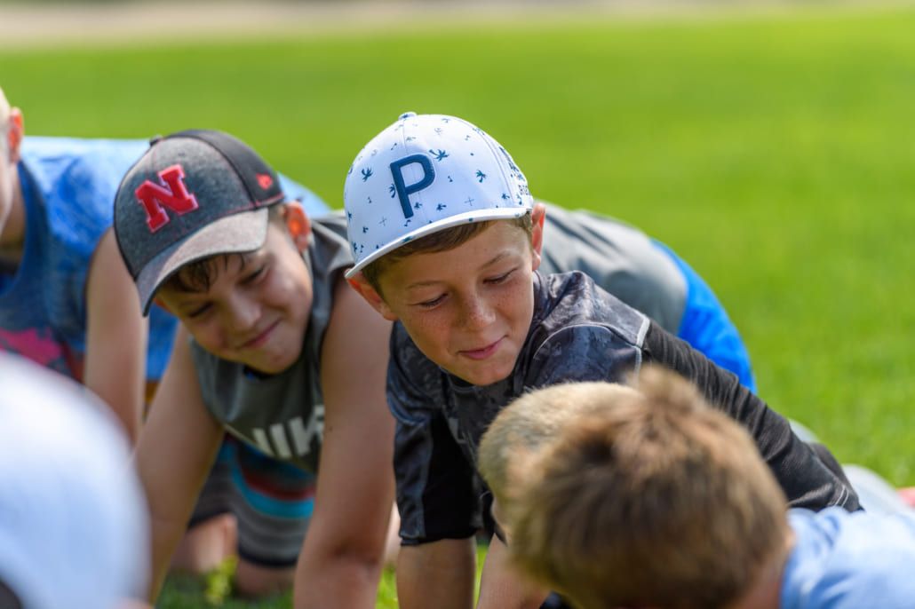 A group of young boys are playing a game of football on a field.