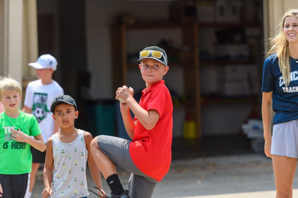 A group of children are standing in front of a garage.