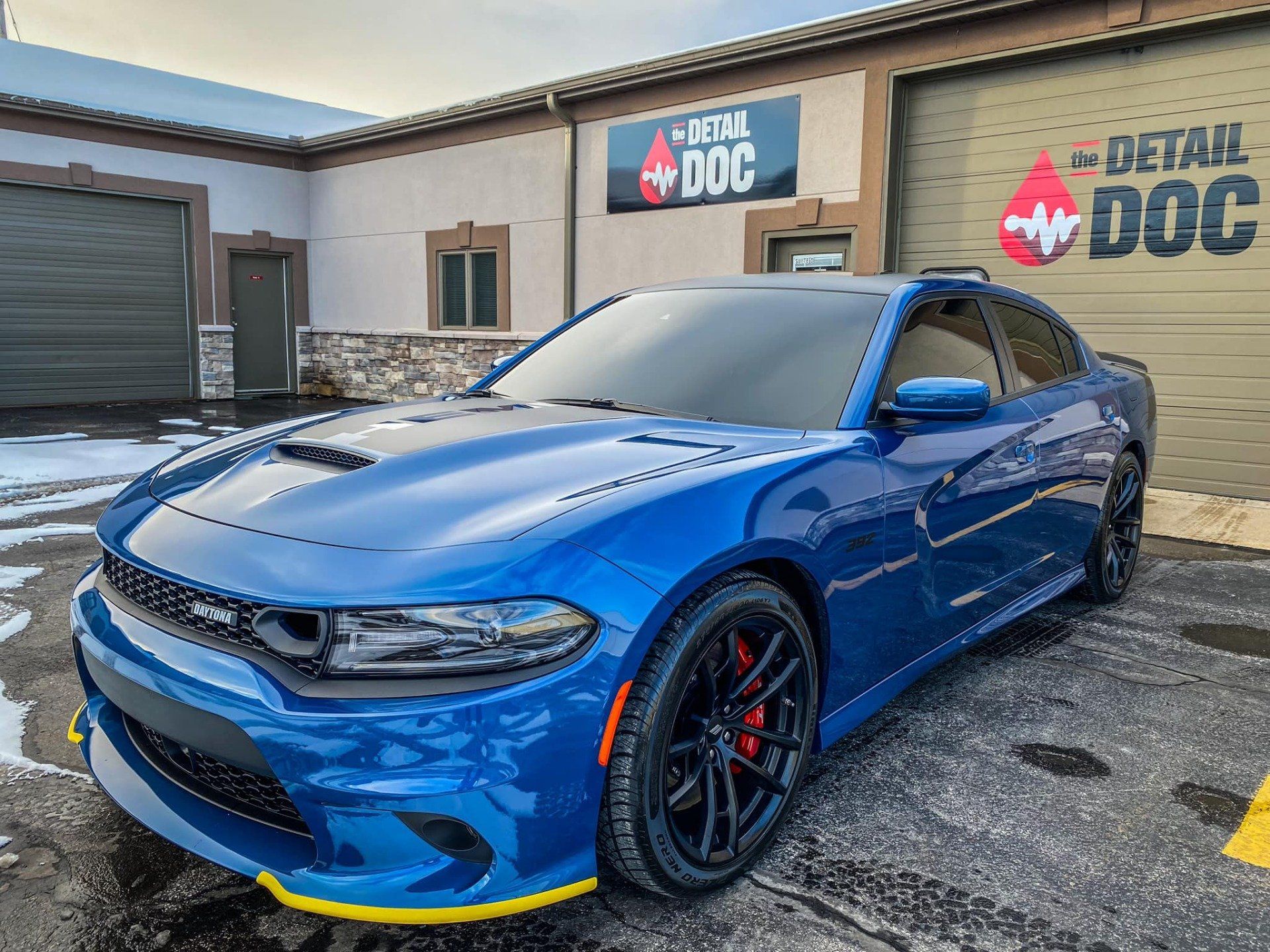 A blue dodge charger is parked in front of a car wash.