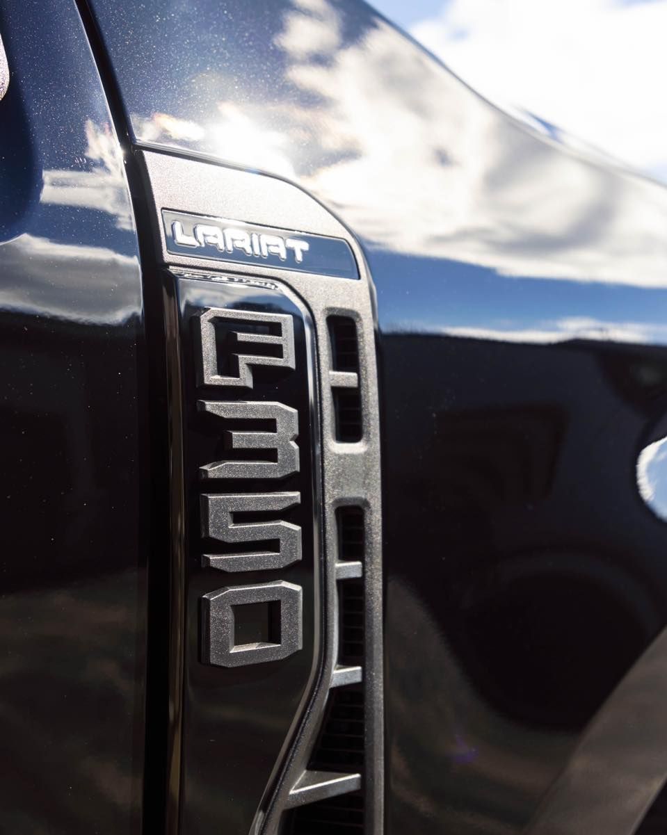 a close up of the side of a black ford truck