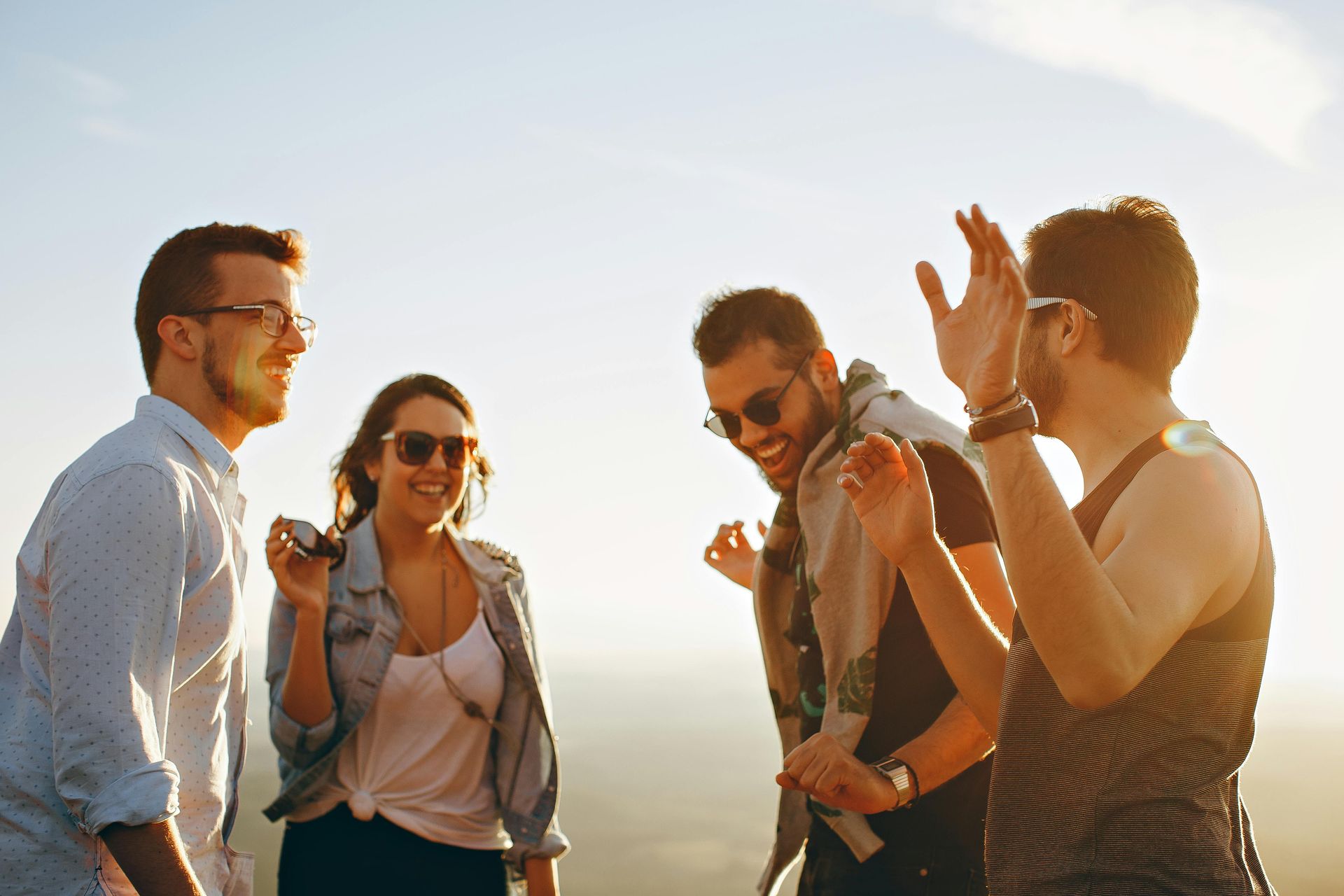 A group of four young adults are having fun together in the sunshine.